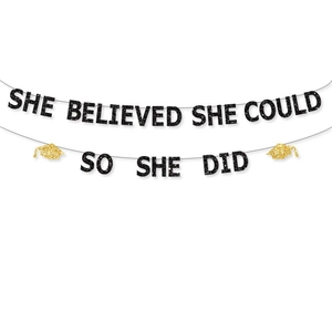 Detail of glittery She Believed She Could So She Did graduation banner with gold grad cap