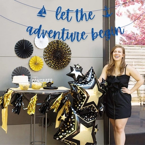 Let the Adventure Begin banner with blue glitter letters, stars and paper fans for party decor
