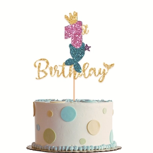 Close-up of glittery mermaid 1st birthday cake topper with pink number and golden crown