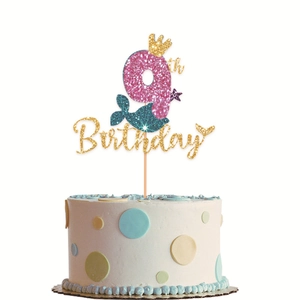 Close-up of pink glitter number 9 mermaid tail cake topper with gold crown and birthday text