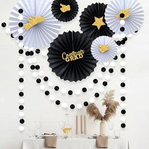 Detail of Congrats GRAD paper fans with gold glitter graduation caps and crown elements