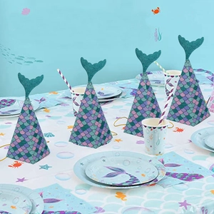 Mermaid party favor boxes with glitter fish tail decor and scales on a festive table