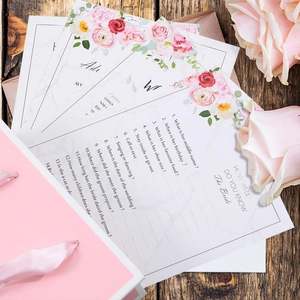 Nahaufnahme der Brautparty-Quizkarten mit Blumendesign auf dunklem Holzhintergrund