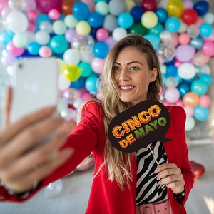 Mexican Cinco de Mayo party photo props with colorful artistic lettering held by a model