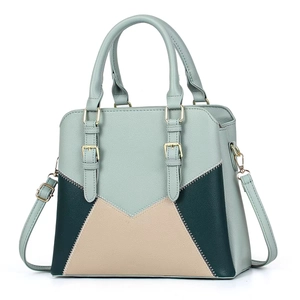 Detail view of tri-color patchwork leather handbag with V-shaped stitching and gold hardware