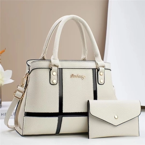 Detail of lychee pattern leather tote with contrast stripes and gold logo lettering