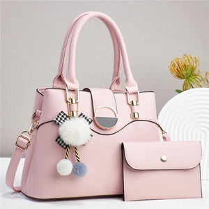 Détail du sac à main rose en similicuir avec portefeuille assorti et charm pompon