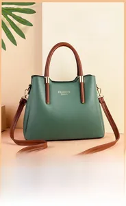 Détail du sac à main en cuir vert foncé avec garnitures dorées et anses marron