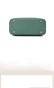 Gros plan détaillé de la base du sac en cuir vert foncé avec pieds de protection dorés