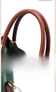 Détail du sac en cuir vert avec poignée caramel et boucle métallique dorée amovible