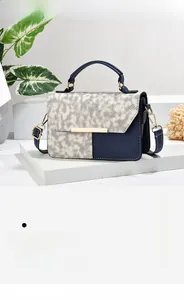 Close-up of contrast stitching on blue and white patchwork leather crossbody bag