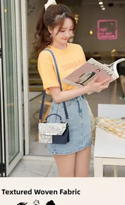 Crossbody bag with navy blue leather and white woven texture panels worn by a model
