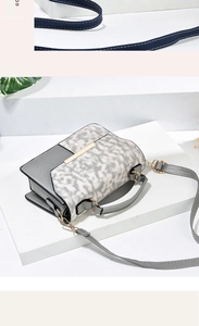 Detail of grey leather handbag with animal print panel and gold metal hardware