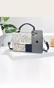 Detail view of woven texture crossbody bag with contrast trim and multi-compartment interior