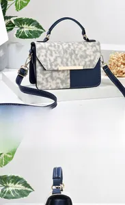 Detail showing mixed texture bag with blue faux leather and gold metal buckle lock