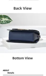 Detail view of navy blue crossbody bag bottom showing stitching and golden hardware