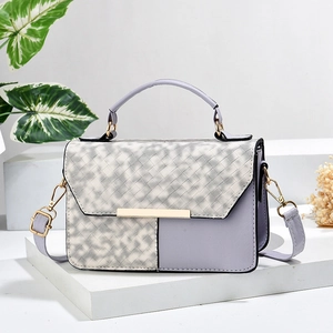 Minimalist lavender patchwork shoulder bag with geometric woven pattern and gold hardware