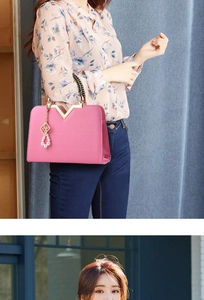 Pink fashion handbag with geometric texture, V-shaped gold clasp and pearl accessory