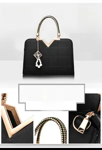 Detail of cross-grain leather texture, woven handle and gold hardware on black handbag