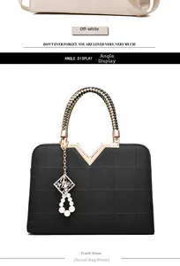 Detail of black faux leather handbag with braided handle and pearl charm decoration