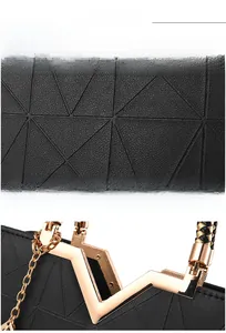 Detail of geometric embossed black leather handbag with gold clasp and woven handle