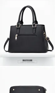Detail of black pebbled leather handbag featuring gold hardware and protective base studs