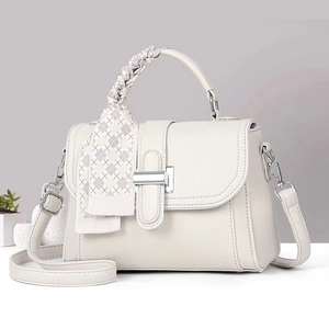 Detail of white leather crossbody bag with silk scarf handle and silver metal hardware