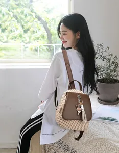 Detail of beige plaid backpack with cute bunny pendant and premium leather trim