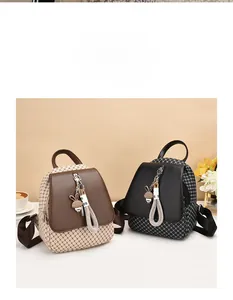 Detail of grid patterned crossbody backpacks in dark brown and black with rabbit charms