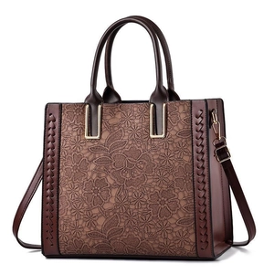 Brown lace embossed tote bag with woven stitch details and gold metallic buckles