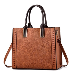 Caramel brown vintage tote bag with floral lace embossing and woven leather details