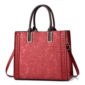 Red large capacity tote bag with intricate floral lace overlay and round top handles