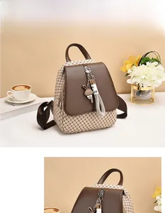 Detail of the brown and beige patchwork backpack featuring a cute rabbit charm and metal zipper