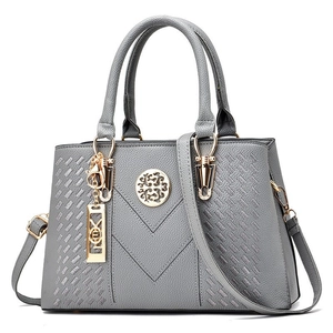 Elegant grey pebbled leather handbag with woven side textures and gold metal accents