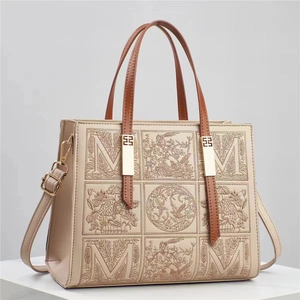Beige tote bag with brown handles and elegant floral embroidery M-logo design