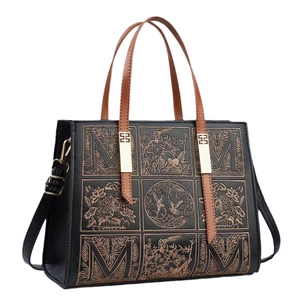 Elegant black embroidered handbag with gold floral patterns and brown leather handles