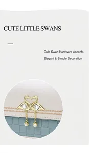 Détail de la quincaillerie cygne en cœur doré avec perles et cristaux sur un sac