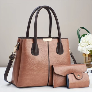 Detailed view of the 3-piece brown leather handbag set including tote, pouch and card holder