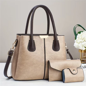 Detailed set of three elegant beige litchi grain faux leather handbags with V-shaped stitching
