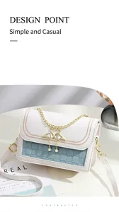 Détail du sac bandoulière blanc et bleu avec chaîne dorée et fermoir cygne sur magazine