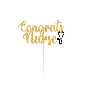 Detail of glittery gold Congrats Nurse cake topper with a stethoscope graphic for nursing graduation
