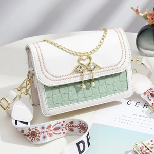Sac carré chic avec matelassage vert menthe, fermoir cygne doré et charms en perles fines