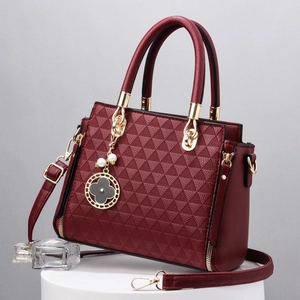 Elegant wine red handbag with triangle embossed pattern and golden clover charm