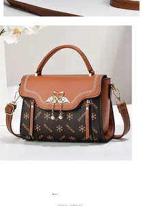 Close-up of golden twin swan lock with small rhinestones and pearl pendants on handbag