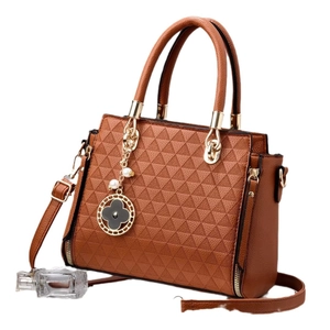 Brown faux leather tote with triangle embossing and a clover charm on white background