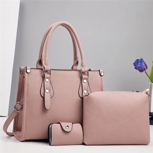 Three-piece pale pink leather handbag set including a large tote, crossbody bag, and wallet