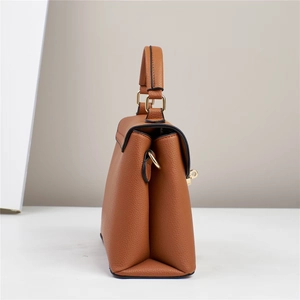 Side view of brown lychee grain leather handbag with gold metal hardware details