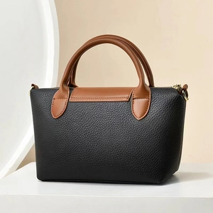 Detail showing high-quality lychee texture leather and premium stitching on the handbag