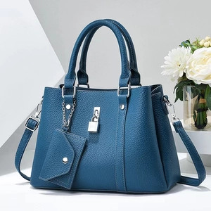 Detail view of navy blue lychee grain leather tote with silver lock and small pouch