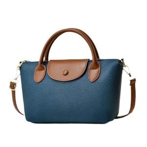 Blue lychee leather handbag with brown handles and a stylish contrast crossbody strap